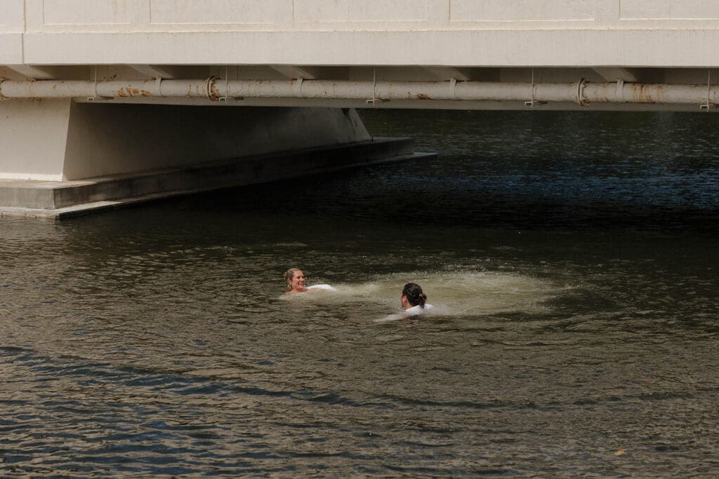 bride and groom jumping off bridge on wedding day in hawaii