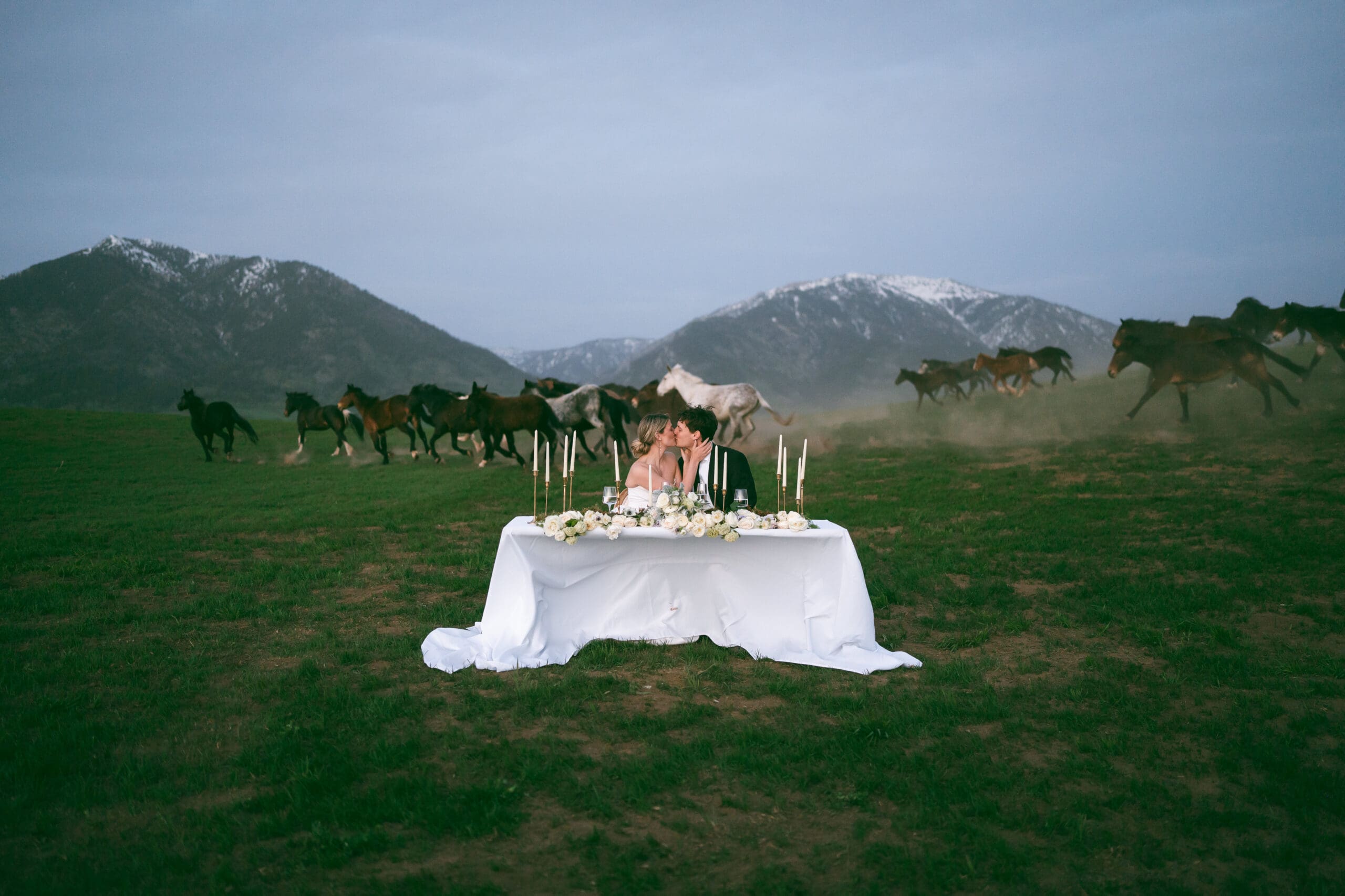 bride and groom on wedding day in jackson hole wyoming with horses running in the background